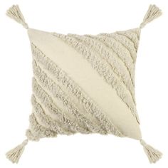 a white pillow with tasselled fringes on the front and back of it