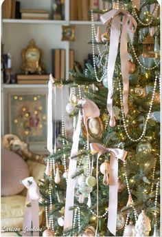 a decorated christmas tree with pink ribbons and ornaments