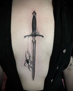 a woman with a tattoo on her back has a knife in the middle of it