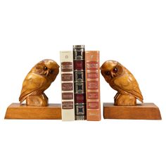 two bookends made out of wood and decorated with owls on top of books