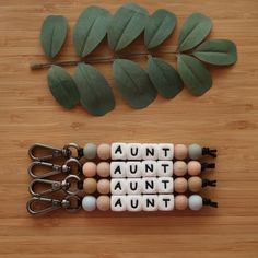 an assortment of wooden beads and scissors on a table next to a plant with leaves