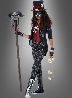 a woman dressed as a skeleton holding a stick and wearing a top hat with skulls on it