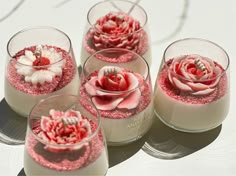 four small glass vases with flowers in them