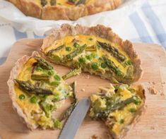 there is a quiche with asparagus on the cutting board