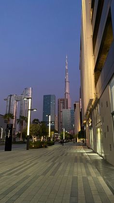 an empty city street with tall buildings in the background