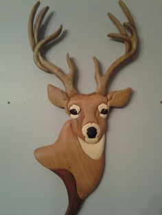 a wooden deer head mounted on the wall