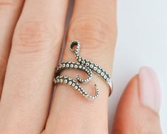 Add a touch of mystical allure to your style with this sterling silver octopus ring. This adjustable tentacle ring wraps around your finger with elegant grace, showcasing the intricate beauty of the sea. Whether you're a fan of punk fashion or a lover of all things oceanic, this ring is the perfect accessory to express your unique personality. Crafted with care and made of high-quality sterling silver, it's a must-have piece for any sea witch or pirate at heart! Rings are sold in sizes 5 6 7 8 9 Octopus Aesthetic, Tentacle Ring, Squid Rings, Tentacles Ring, Punk Mode, Witch Ring, Ring Wraps, Wrap Around Ring, Octopus Ring