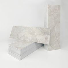 two stacks of white marble cards stacked on top of each other in front of a white background