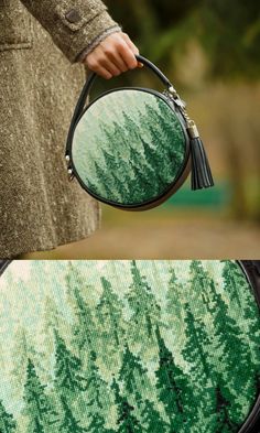 a person holding a round mirror with trees on it