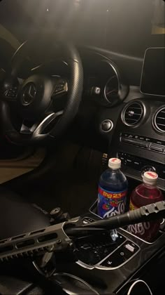 the interior of a car with an automatic steering wheel and drink in front of it