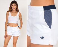 "Vintage 80s tennis shorts by Adidas in white with dark blue terry cloth trim on the sides. Please see measurements and condition below. Every garment we sell is authentic vintage! You will receive the exact item photographed. Condition: Very good vintage. Best fits men's: Labelled 32 Best fits women's: Medium  Tag: adidas Material:  Polyester MEASUREMENTS Taken from seam to seam while the garment is lying flat. Double the armpit, waist, and hips For reference, model is 5'9\" and measures 35-27. Sporty Cotton Tennis Bottoms, White Cotton Tennis Bottoms, Summer Cotton Tennis Shorts, Cotton Tennis Shorts, Cotton Shorts With Contrast Trim For Summer, Tennis Bottoms With Built-in Shorts, Retro Athletic Shorts For Sports, Cotton Tennis Bottoms With Built-in Shorts, Retro White Fitted Shorts