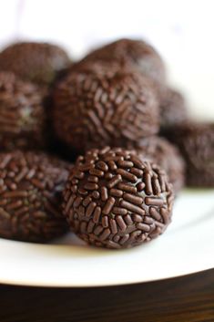 chocolate balls on a white plate with brown sprinkles