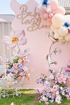 a baby shower sign with balloons and flowers