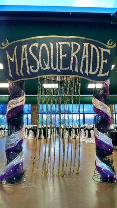 the entrance to masquerade is decorated with purple and white ribbons, streamers, and beads