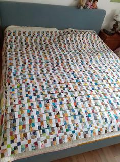 a bed with a colorful quilt on top of it