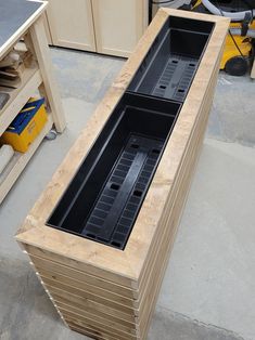 a large wooden box sitting on top of a floor next to a workbench