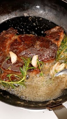 a pan filled with meat and vegetables on top of a stove