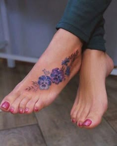 a close up of a person's foot with purple flowers on the toe and bottom