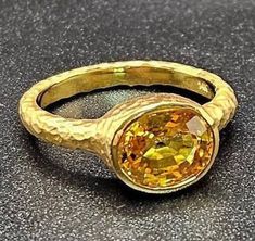 14k solid yellow gold hammered ring with 3.75 ct. 10x8 mm oval shape natural yellow sapphire, this item can also be ordered in white or rose gold with different color gemstones such as, amethyst, pink amethyst, green amethyst, blue topaz, London blue topaz, white topaz, citrine, garnet, smoky quartz, peridot, aquamarine, morganite & pink tourmaline, please contact me for a quote as each gemstone varies in price. I am a manufacturer of fine jewelry for over thirty years, loyalty and customer satisfaction have always been my ultimate goal. Please don't hesitate to contact me with any questions or ideas you may have. CUSTOM ORDERS ARE ALWAYS WELCOME. All my pieces come with a lifetime warranty. GOLD WEIGHT: 6.9 grams of solid 14k yellow gold. GEMSTONE INFO: 3.75 ct. 10x8 mm oval shape natural Yellow Sapphire Oval Ring In Fine Jewelry Style, Fine Yellow Oval Sapphire Ring, Oval Yellow Sapphire Diamond Ring, Luxury Yellow Oval Sapphire Ring, Yellow 14k Gold Oval Rings, Elegant Yellow Oval Sapphire Ring, Oval Yellow Sapphire Ring In Yellow Gold, Classic Oval Yellow Sapphire Ring, Elegant Oval Yellow Sapphire Ring