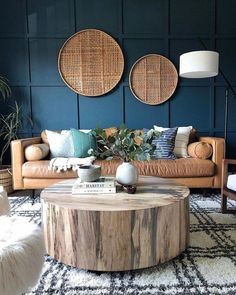 a living room filled with furniture next to a wooden table and two wall hangings