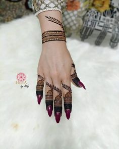 a woman's hand with henna tattoos on it