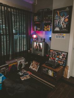 a living room filled with furniture and pictures on the wall next to a window covered in blinds