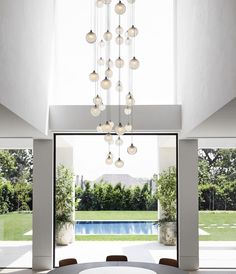 a dining room table with chairs and a chandelier hanging from it's ceiling