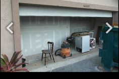 an overhead garage door with two chairs and a small refrigerator in the corner next to it