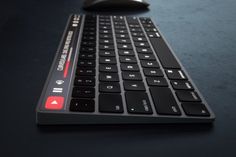 a computer keyboard and mouse sitting on a table with a black surface in the background