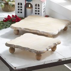 two wooden trays sitting next to each other on a white table with christmas decorations