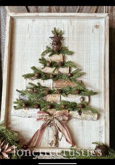 a christmas tree made out of wine corks is displayed in a frame with pine cones