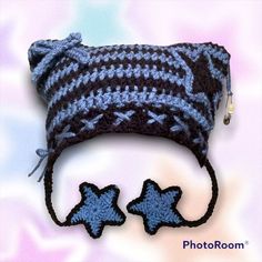 a crocheted hat with two little blue stars on the front and one small black star on the back