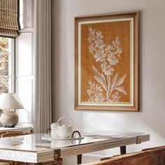 a dining room table with two chairs and a painting hanging on the wall above it