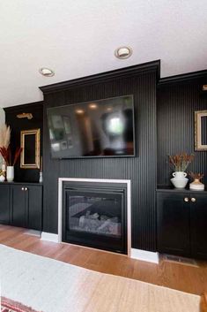 a living room filled with furniture and a flat screen tv mounted on the wall above a fire place