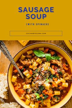 sausage soup with spinach and carrots in a yellow bowl on a wooden table