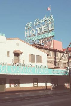 an old building with a neon sign on top