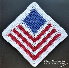 a red, white and blue crochet dishcloth on a black table top