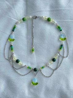 a green and white beaded necklace with leaves