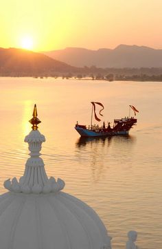 two boats are in the water at sunset