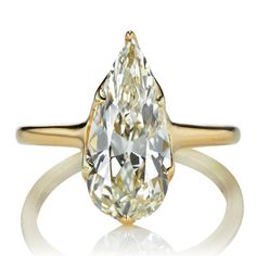 a yellow gold ring with a pear shaped diamond