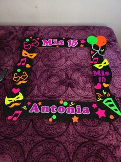 the letter e is decorated with masks, balloons and confetti on purple fabric