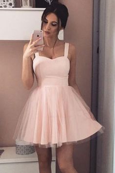 a woman taking a selfie in a pink dress