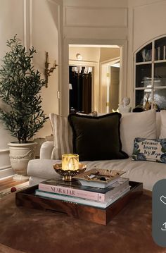 a living room filled with lots of furniture and books on top of a coffee table