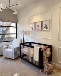 a baby's room with a giraffe stuffed animal in the crib