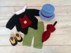 a crocheted outfit, hat and booties are laid out on the floor