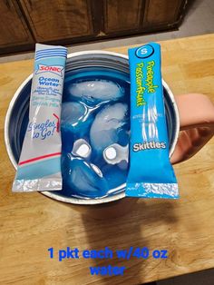 an ice bucket filled with water and two packets of toothpaste