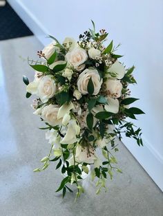 a bouquet of white flowers sitting on top of a counter next to a door way