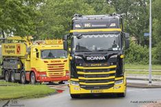 two large trucks driving down the road next to each other