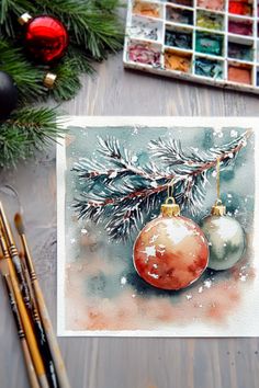 A winter watercolor painting featuring pine branches and ornaments with snowy accents, surrounded by art supplies and pine greenery. Christmas Watercolor Tutorial, Watercolor Painting Ideas For Beginners, Watercolor Christmas Cards Diy, Ornament Painting, Watercolor Painting Ideas, Painting Ideas For Beginners, Watercolor Paintings For Beginners, Winter Watercolor, Pine Branches