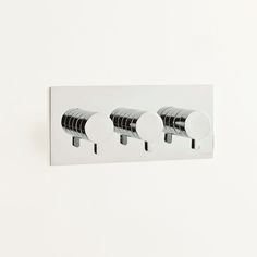 three black and white toilet paper holders on a wall